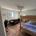 Slaapkamer met stapelbed, bank en bureau