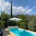 Uitzicht tuin Villa Beauregard op de heuvels van de Ardèche <br>De vaste parasol geeft extra schaduw in en om het zwembad. Er is een tweede parasol aanwezig die verplaatst kan worden. Hierdoor is er altijd en overal extra schaduw in de tuin te creëren.