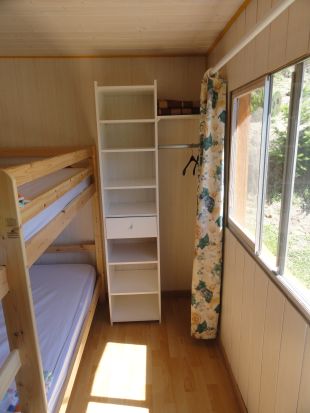 Slaapkamer met stapelbed en open kast