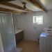 Badkamer met douche en wasbak en wasmachine