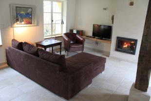 Woonkamer met zitbank en kachel