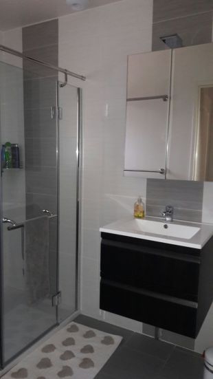 Badkamer met douche en lavabo