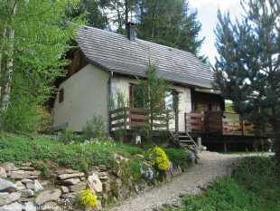 Ons chalet gezien vanaf de weg <br>Het chalet ligt een flink stukje hoger dan de weg. Dat zorgt voor een mooi uitzicht en veel privacy.