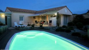 Onze villa met de zwembadverlichting in de avond