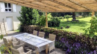 Terras met zonnescherm <br>Het is heerlijk vertoeven op het terras met een zonnescherm van riet.