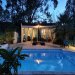 Poolhouse bij avond <br>Het romantische poolhouse met de extra slaapkamer. Zo vanuit je bed het zwembad in.