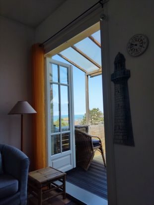 Woonkamer met openslaande deuren naar balkon met zeezicht