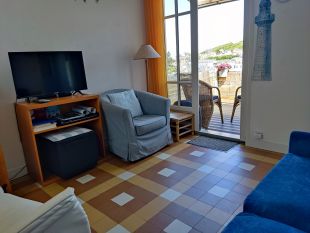 Woonkamer met openslaande deuren naar balkon met zeezicht