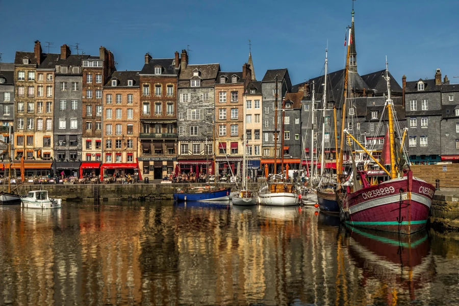 De schilderachtige oude haven van Honfleur met zijn karakteristieke hoge, smalle huizen die het water weerspiegelen.